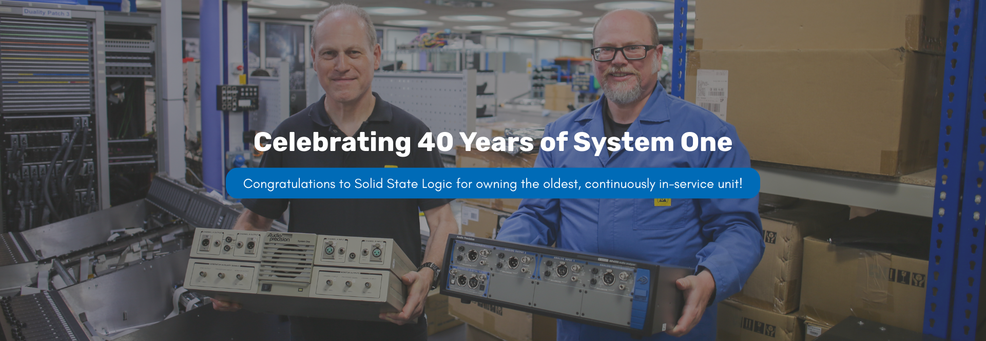 Clive Heath and Daniel Knighten holding Audio Precision analyzers